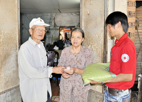 Cụ Nguyễn Văn Thư trao quà cho người nghèo.