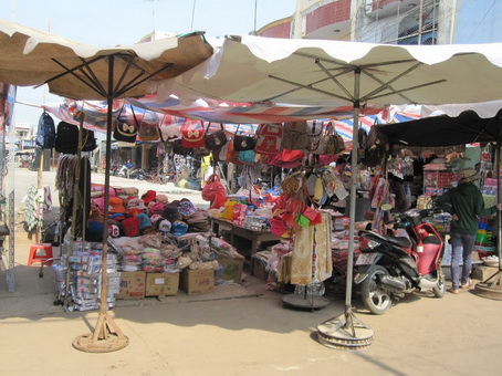 Một số tiểu thương phải che dù, căng bạt để có chỗ buôn bán