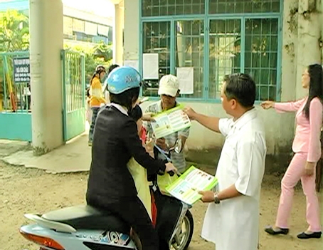 Cán bộ Trung tâm y tế huyện Long Thành cấp tờ rơi tuyên truyền phòng dịch bệnh cho người dân. Ảnh: V. Quỳnh