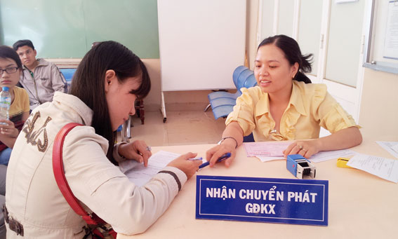  Nhân viên bưu điện hướng dẫn người dân đăng ký chuyển GĐKX về nhà.