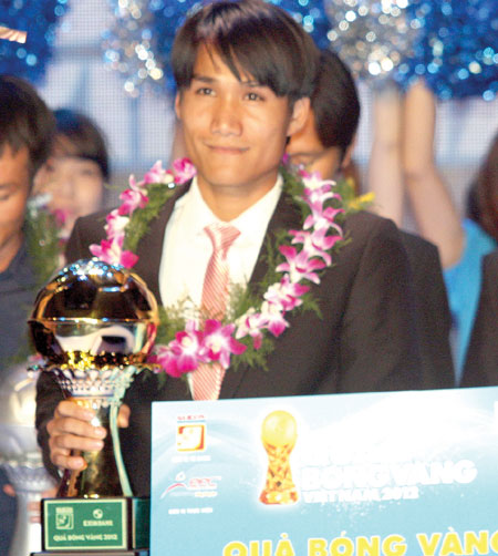 Huynh Quoc Anh raise trophies at the Golden Ball award ceremony held in HCM City last night.