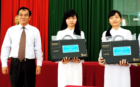 Secretary Tran Dinh Thanh presents laptop computers to outstanding students.