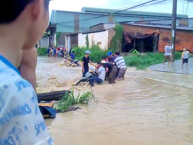 Cơn mưa chiều 19-5 làm đường trong ấp Lộ Đức ngập lênh láng khiến nhiều người bị mất lái, té ngã.