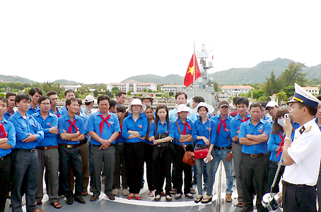 Các thành viên trong đoàn tham quan và nghe cán bộ, chiến sĩ Hải quân Vùng 4 giới thiệu về một số loại tàu.