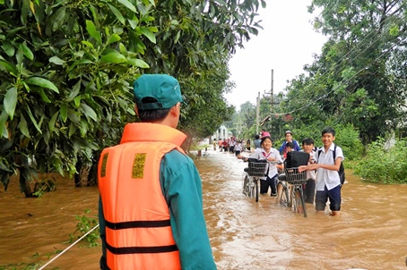 Lực lượng dân quân hỗ trợ các em học sinh sau khi tan trường.