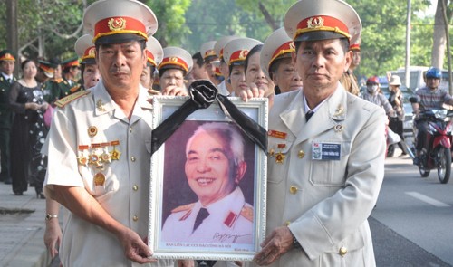 Vietnamese war veterans are holding a photo of the late General Vo Nguyen Giap, who died on October 4