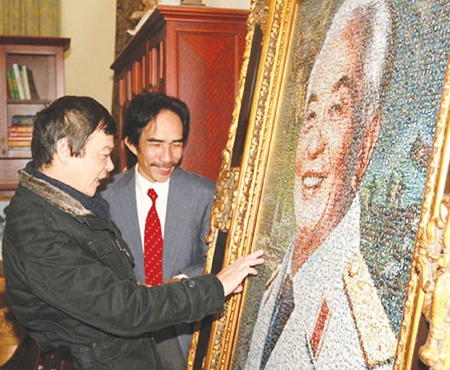 Picturing greatness: Painter Nguyen Minh (right) and General Giap's eldest son Vo Dien Bien next to a photo-collage portrait of General Giap made by Minh using 8,800 smaller photos of the general. 