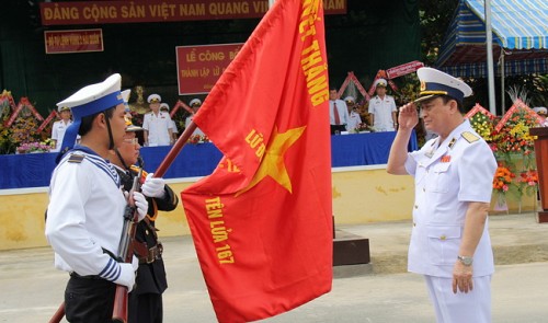 Admiral Nguyen Van Hien, Deputy Defense Minister and Commander of Vietnam People's Navy, hands the brigade's flag to the brigade's commander