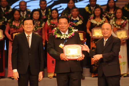 President Truong Tan Sang (L) and Nguyen Quoc Cuong (R), chairman of Farmer Association give merit certificate to a farmer 