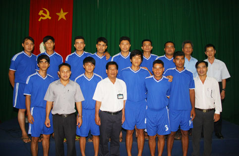 Ông Điểu Bảo (áo trắng, giữa) chụp hình với đội bóng chuyền tại buổi lễ
