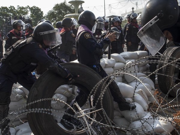 Cảnh sát chống bạo động Thái Lan dỡ bỏ chướng ngại vật người biểu tình dựng bên ngoài tòa nhà chính phủ ở Bangkok. (Nguồn: AFP/TTXVN)