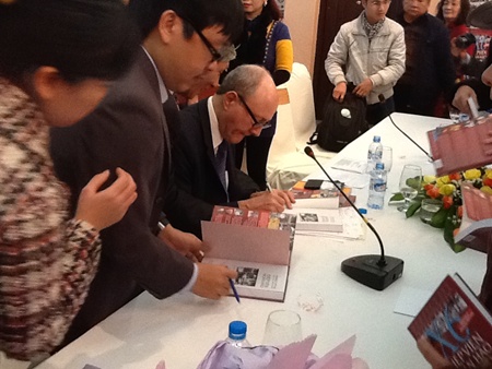Professor Larry Berman signs copies of the new edition of his book about the legendary spy Pham Xuan An for readers during the book launch in Ha Noi on Tuesday.