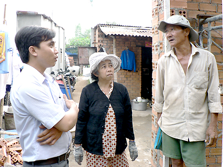 Cán bộ Mặt trận xã Đại Phước (trái) thăm một hộ dân đang được hỗ trợ để xây dựng nhà tình thương.