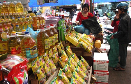 Customers purchase goods from shops in My Tho market in Nam Dinh province. Domestic consumption demand is being stymied as locals curb spending habits and focus on buying only essential goods and services. 