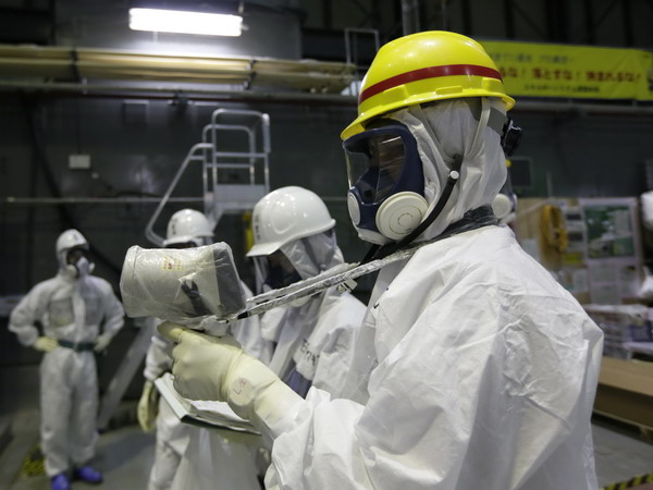 Các kỹ thuật viên đo độ phóng xạ tại các bể ngâm thanh nhiên liệu ở nhà máy Fukushima 1. (Nguồn: AFP-TTXVN)