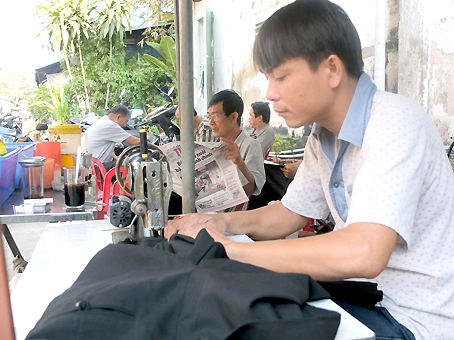 Anh Thuận miệt mài với bàn máy sửa quần áo từ 7-17 giờ mới về nhà.