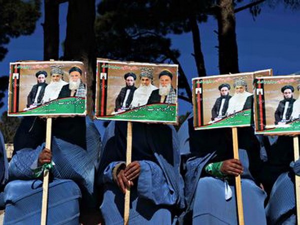 Những người ủng hộ trưng ảnh của các ứng cử viên. (Nguồn: AFP)