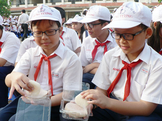 Học sinh cùng nhau thưởng thức món bánh giầy truyền thống của dân tộc.