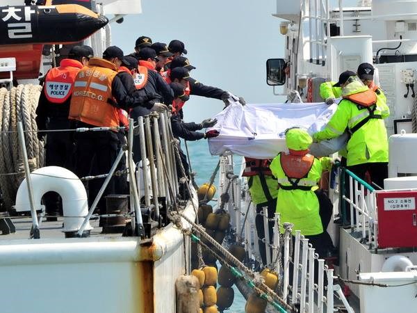 Lực lượng bảo vệ bờ biển Hàn Quốc chuyển xác nạn nhân từ con phà bị chìm ngày 20/4. (Nguồn: AFP/TTXVN)