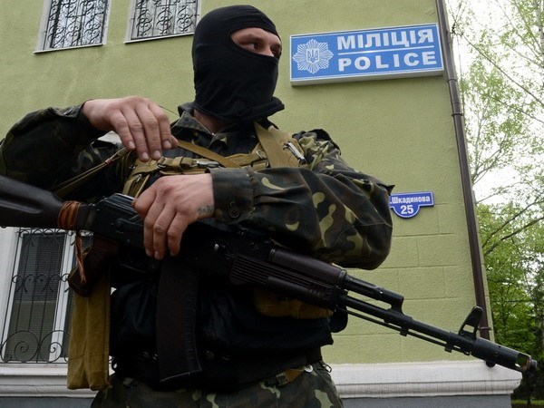 Một tay súng không rõ danh tính gác bên ngoài trụ sở cơ quan cảnh sát ở Kramatorsk, Ukraine ngày 22/4. (Nguồn: AFP/TTXVN)