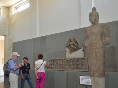 Tourists inspect sculptures at the Cham Museum 