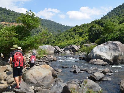 Tourists walk along the stream to reach Vuc Phun