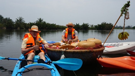 Paddling adventure: Tourists kayaking in the river enjoy some food and drinks at a floating bar. The tour has recently been introduced in Hoi An.