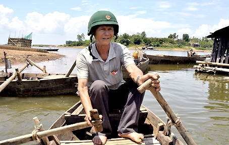 Hàng ngày, ông Năm Thu vẫn tự mình chèo xuồng đến hỏi thăm các gia đình sống trên lồng bè cá.