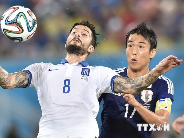 Trung vệ Panagiotis Kone (trái) đội tuyển Hy Lạp khống chế bóng bổng trước trung vệ Makoto Hasebe, đội tuyển Nhật Bản. (Nguồn: AFP/TTXVN)