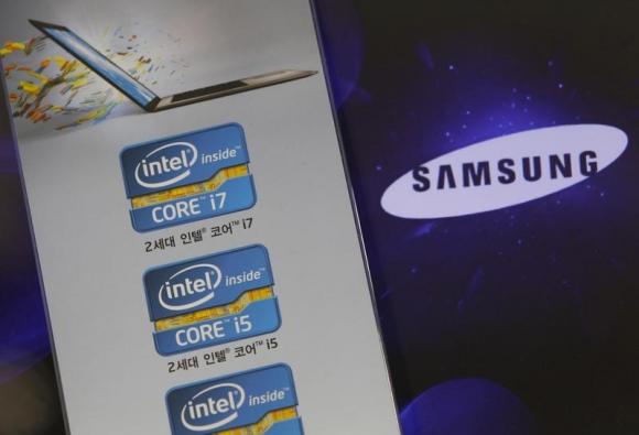 The Samsung Electronics logo is seen on a laptop computer screen (R) in front of an advertisement board promoting Intel processors at a store in Seoul June 21, 2012.