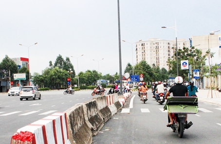 Người tham gia giao thông rẽ trái ngay tại khu vực chân cầu Hóa An, trong khi bảng báo chỉ dẫn hướng rẽ cách đó 100m.