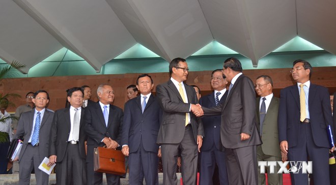 Thủ tướng Hun Sen, Trưởng Đoàn đàm phán CPP và Chủ tịch CNRP Sam Rainsy bắt tay nhau sau cuộc đàm phán cấp cao kéo dài 5 giờ, ngày 22/7. 
