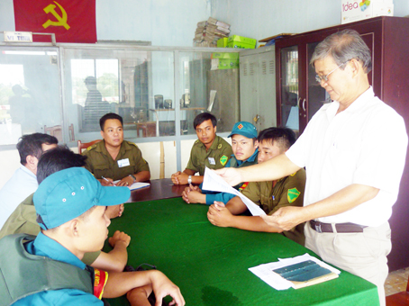 Ông Tư Mai (đứng) báo cáo trong buổi giao ban về an ninh trật tự tại Công an xã Tân Bình (huyện Vĩnh Cửu).