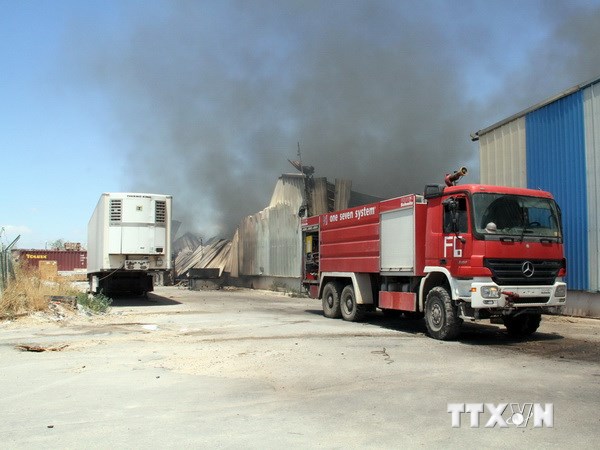 Xe tải bị đốt cháy trong vụ tấn công vào sân bay Tripoli. (Ảnh: THX/TTXVN)