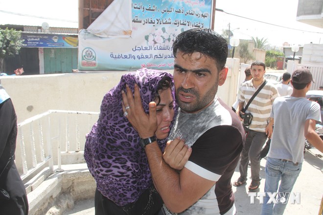 Một người Palestine an ủi người thân đang hoảng loạn sau vụ không kích của Israel vào thành phố Rafah ngày 1/8. (Nguồn: AFP/TTXVN)