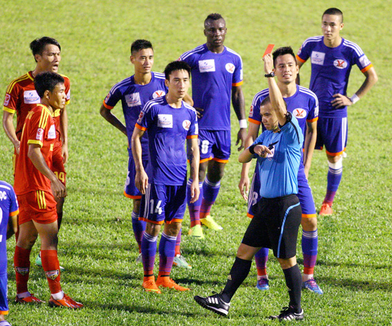 Trọng tài Phùng Đình Dũng rút thẻ đỏ giành cho cầu thủ hai đội An Giang và Than Quảng Ninh ở vòng 22.                                                                                                                 Ảnh: T.L