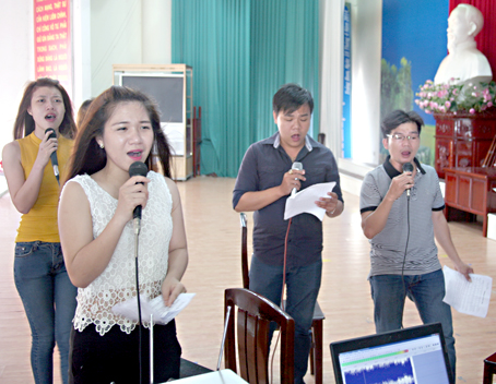 Kim Ngân (người đứng đầu, trái) đang cùng các thành viên trong Đội Tuyên truyền ca khúc cách mạng Trung tâm Văn hóa - thể thao huyện Trảng Bom luyện tập chương trình văn nghệ phục vụ nhân dân.