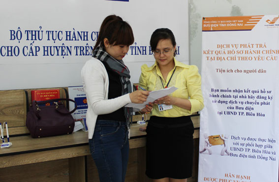 Nhân viên bưu điện hướng dẫn người dân đăng ký dịch vụ chuyển phát nhanh tại bộ phận một cửa TP.Biên Hòa