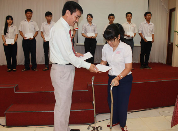 Deputy General Director Nguyen Si Phong of Cuong Thuan Idico hands scholarships to university students.