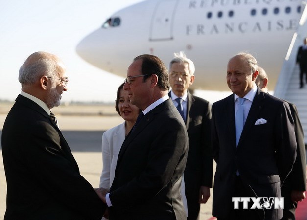 Ngoại trưởng Iraq Ibrahim al-Jaafari (trái) đón Tổng thống Francois Hollande (giữa) tại sân bay quốc tế Baghdad. AFP-TTXVN