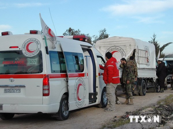 Nhân viên Hội Lưỡi liềm đỏ Syria hỗ trợ người dân sơ tán vùng chiến sự tới khu vực do quân đội kiểm soát ở Homs. (Nguồn: AFP/TTXVN)