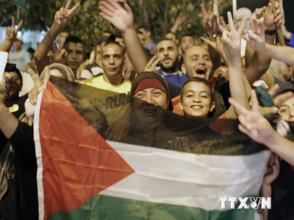 Người dân Palestine vui mừng vì hiệp ước ngừng bắn mới, tại Đông Jerusalem ngày 26/8. (Ảnh: AFP/TTXVN)