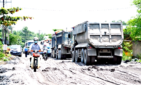 Hàng trăm lượt xe tải ben phóng ào ào mỗi ngày làm cho đường Tân Cang nhanh chóng xuống cấp.  ảnh: V.CHÍNH