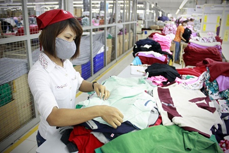 Workers check products at Korean-invested Shinwon Ebenezer Ha Noi Co Ltd. 
