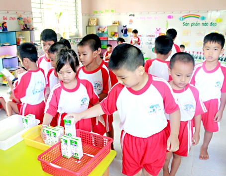 Trẻ mầm non Trường tiểu học Họa Mi, huyện Cẩm Mỹ lần lượt lên nhận sữa để uống.