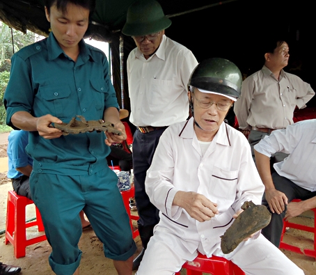 Ông Hồ Văn Hậu (thứ ba từ trái sang), nguyên cán bộ dân chính TX.Long Khánh, cầm trên tay chiếc dép râu của liệt sĩ được tìm thấy.