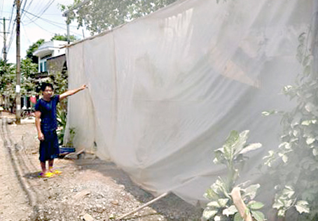 Để hạn chế bụi bay vào nhà, người dân hai bên quốc lộ 20, phải dùng bạt che quanh nhà.