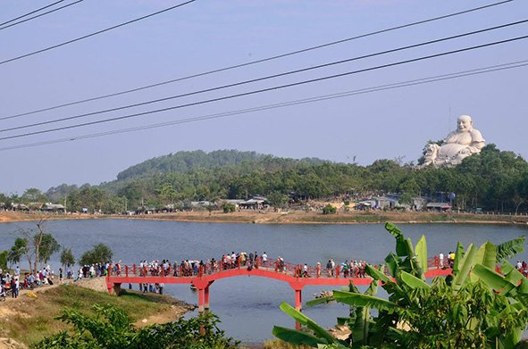 People walk on a bridge to get to Phat Lon Pagoda in Cam Mountain -