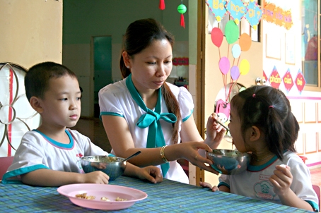 Cô giáo Lưu Yến Trâm chăm sóc bữa ăn cho các bé.