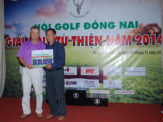 Chủ tịch Hội Golf Đồng Nai Lê Nhất Đinh (trái) trao số tiền vận động được cho đại diện xã Xuân Bắc